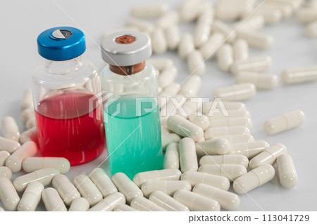 On a white table in the laboratory, scattered ampoules and bottles with liquid chemical reagents. On a white table in the laboratory, scattered ampoules and bottles with liquid chemical reagents. 113041729