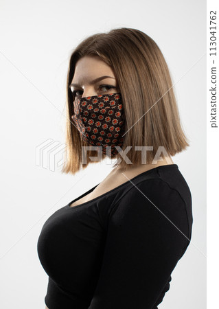 For safety, a young teenager stands in a protective mask during an ongoing pandemic. For safety, a young teenager stands in a protective mask during an ongoing pandemic. 113041762