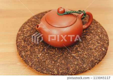 Traditional yixing clay teapot with pressed pu-erh black tea disc for tea brewing 113043117