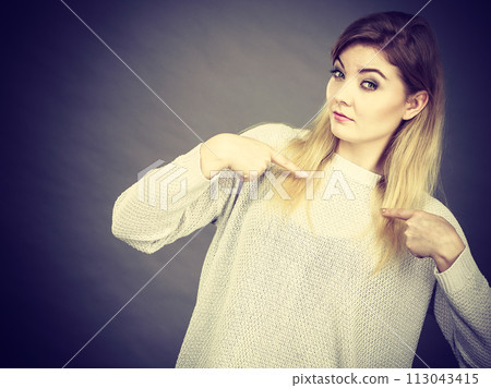 Confused woman pointing at herself Confused woman pointing at herself 113043415