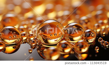 Oil drops on water. Oil spheres floating in a golden liquid. Bubbles of different sizes on orange abstract background 113043519