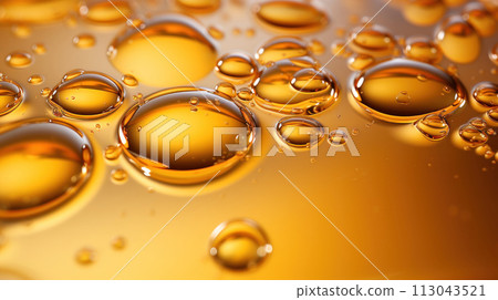 Oil drops on water. Oil spheres floating in a golden liquid. Bubbles of different sizes on orange abstract background 113043521