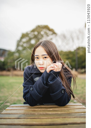 High school girl sitting at a table and taking a break outdoors 113043920