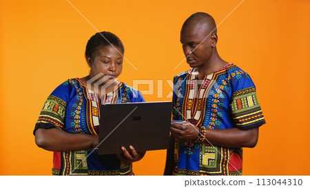 Ethnic man and woman doing online shopping on website, using laptop to fill in credit card details for electronic bank payment. Happy wife buying clothes on store webpage, web transaction. Ethnic man and woman doing online shopping on website, using laptop to fill in credit card details for electronic bank payment. Happy wife buying clothes on store webpage, web transaction. 113044310