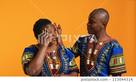 Husband comforting wife with painful headache on camera, dealing with stress and tension. Young man trying to help woman who feels unwell and sick, person rubbing temples to ease migraine pain. 113044314