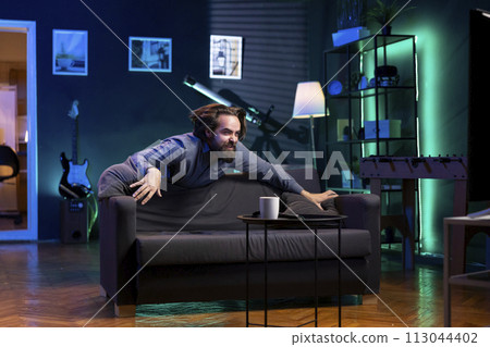 Maniac fan enjoying seeing favorite team win while watching live sports event broadcasted on TV. Overjoyed supporter depleted of energy after celebrating club getting victory in football competition 113044402