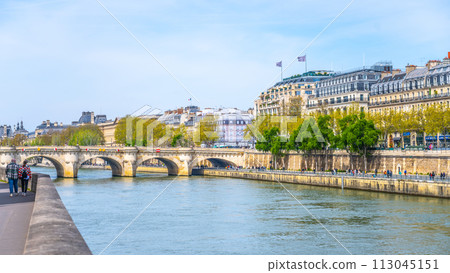 A view of the tranquil Pont Neuf over the Seine with pedestrians enjoying the riverside scene. Paris, France A view of the tranquil Pont Neuf over the Seine with pedestrians enjoying the riverside scene. Paris, France 113045151