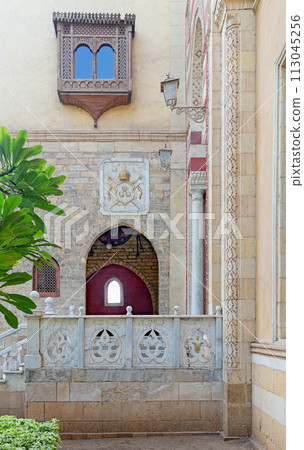 Serene view of a rustic style building featuring an arched balcony, and detailed window grills Serene view of a rustic style building featuring an arched balcony, and detailed window grills 113045256