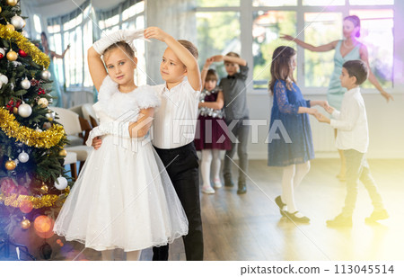 Preteen children in elegant outfits practicing partner dance in Christmas studio 113045514