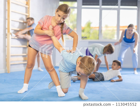 Girls and boys of performing protection with wring hands during training in self-defense 113045552