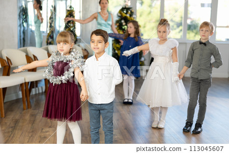Tween boy and girl performing waltz during Christmas event at school 113045607