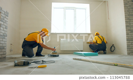 Priming floor in a large house. Workers insulated floor. 113045788