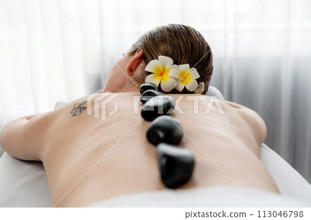 Hot stone massage at spa salon in luxury resort. Quiescent 113046798