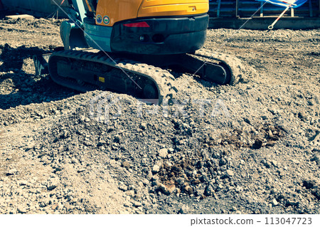 地面平整和挖土機下的施工現場，強調暖色和冷色 113047723
