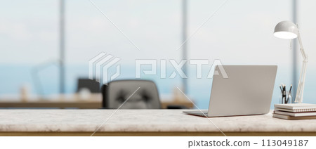 A back view image of a laptop computer on a white marble desk in a modern spacious office. A back view image of a laptop computer on a white marble desk in a modern spacious office. 113049187