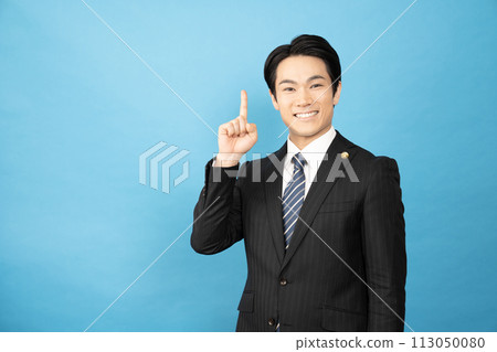 A lawyer smiling with his index finger up on a blue background A lawyer smiling with his index finger up on a blue background 113050080