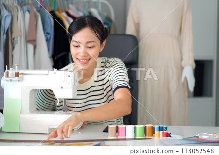 Happy beautiful Asian young woman working in the fashion design studio, professional female fashion designer portrait in design studio. 113052548