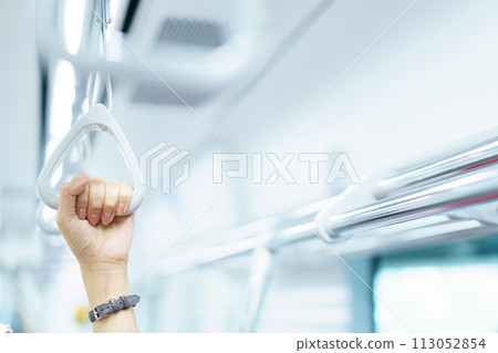 Happy Asian female tourist traveling in across the country by railway transportation system. Woman holding on the handle grip while traveling in the train. 113052854