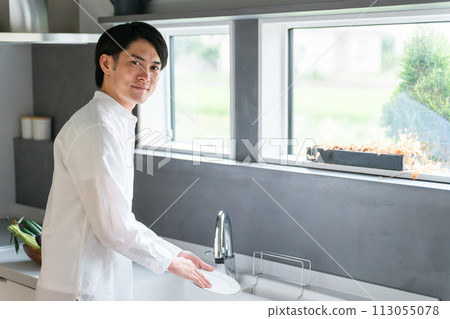 年輕的亞洲男子在家裡的廚房洗碗 年輕的亞洲男子在家裡的廚房洗碗 113055078