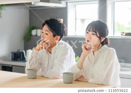 A young couple with a cold expression sitting in the dining room (marital relationship, boredom, rut, masked couple, marital quarrel) A young couple with a cold expression sitting in the dining room (marital relationship, boredom, rut, masked couple, marital quarrel) 113055622