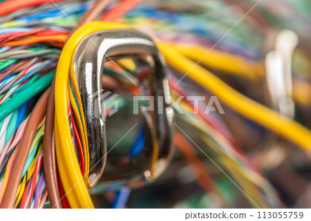 Colored electrical cable on hook of organizer, macro view with blurred background 113055759