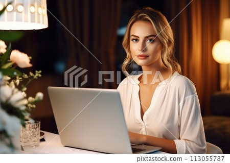 Female using laptop computer playing social media, or streaming video on night at home 113055787