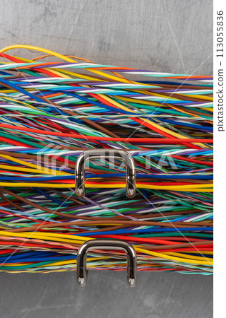 Colored electric cable on hooks of organizer 113055836