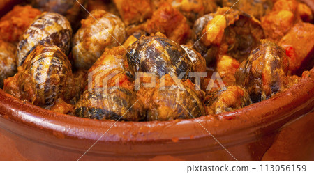 The boiled snails in tomato sauce with garlic and chili in iron pan The boiled snails in tomato sauce with garlic and chili in iron pan 113056159