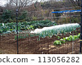 A field in a hilly and mountainous farmland with a fence installed to prevent animal damage. 113056282