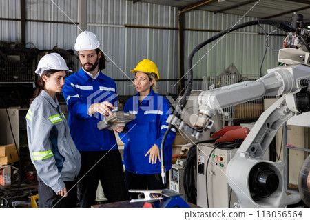 Team engineer using remote robot controller operate standing at automation robot arms machine 113056564