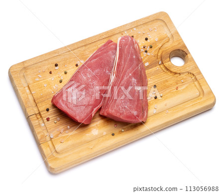 Fresh tuna Fish steak on a wooden cutting serving board isolated on a white background Fresh tuna Fish steak on a wooden cutting serving board isolated on a white background 113056988