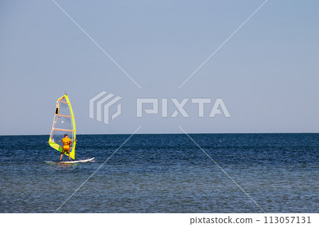 Windsurfing. Surfer exercising in calm sea or ocean. 113057131