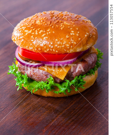 Tasty grilled hamburger with pork patty, tomato, cheese and lettuce Tasty grilled hamburger with pork patty, tomato, cheese and lettuce 113057554