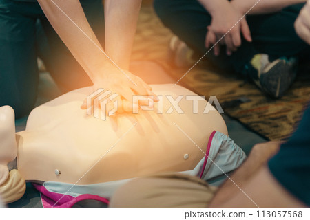 CPR First Aid Training with CPR dummy in the class. Demonstrating chest compressions concept. 113057568