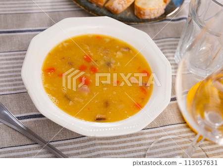 Hot pea soup with smoked meats and vegetables 113057631