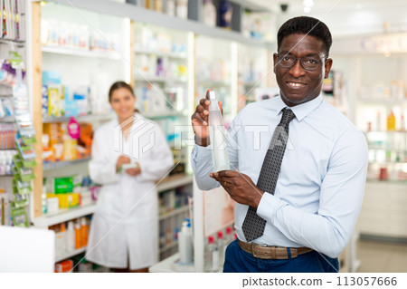 Man standing in drugstore 113057666
