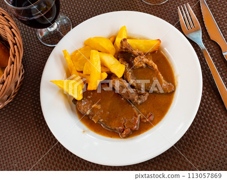 Stewed beef in sauce served with potatoes on platter Stewed beef in sauce served with potatoes on platter 113057869