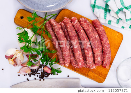 Fresh sausages longaniza on chopping board Fresh sausages longaniza on chopping board 113057871