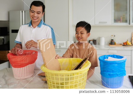 Proud father teaching son to sort and categorize trash 113058006