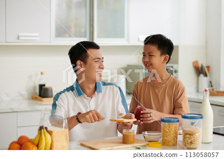 Happy Vietnamese father and son making sandwiches for breakfast Happy Vietnamese father and son making sandwiches for breakfast 113058057