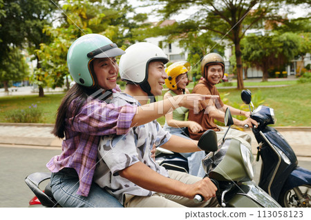 Two smiling Vietnamese couples riding motorbikes Two smiling Vietnamese couples riding motorbikes 113058123