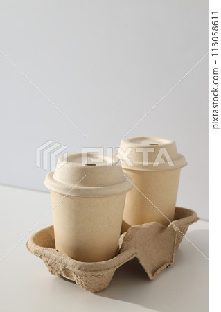 Paper cups with lids on a light background Paper cups with lids on a light background 113058611