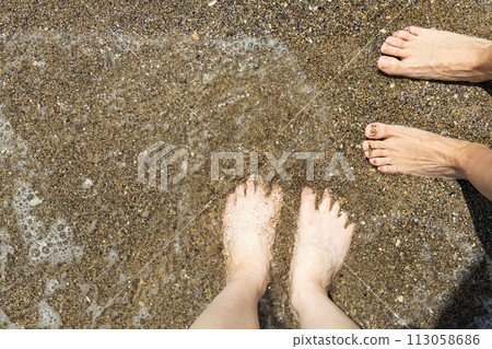A man walks barefoot on the sand on the beach. A man walks barefoot on the sand on the beach. 113058686