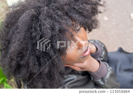 Dreamy Gaze: Upward Looking African American Woman with Voluminous Afro Dreamy Gaze: Upward Looking African American Woman with Voluminous Afro 113058864