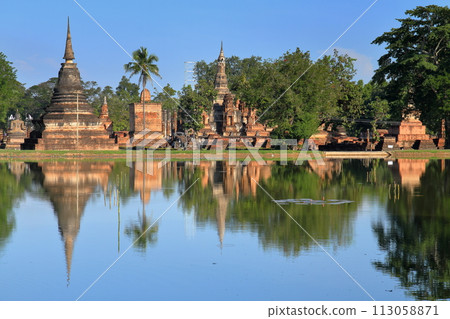 Wat Mahathat ruins and pond water mirror in Sukhothai Historical Park, a world cultural heritage site in Sukhothai, the ancient capital of northern Thailand 113058871