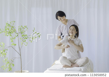 A middle-aged female chiropractor who performs treatment on young women 113058952