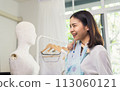Beautiful Asian woman choose on clothing in a clothing store with mannequins. 113060121