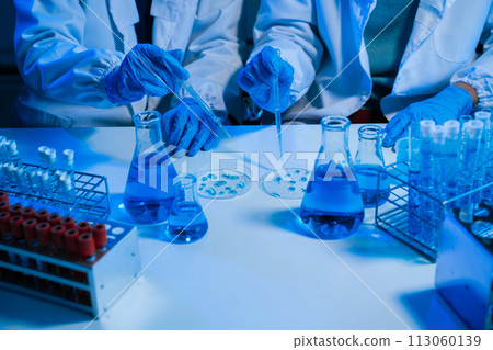 Science and medicine, scientist analyzing and dropping a sample into a glassware, experiments containing chemical liquid in laboratory on glassware, innovative and technology. 113060139