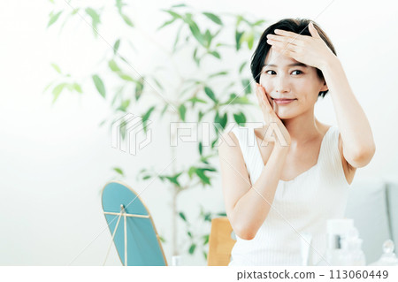 A woman taking care of her skin in the living room 113060449