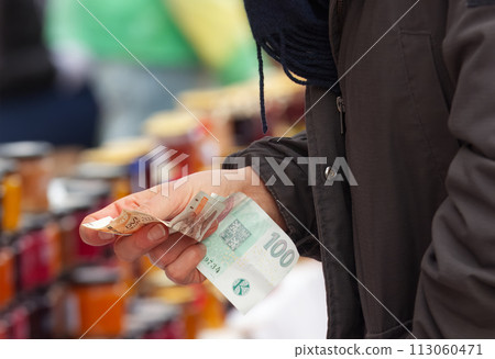 Payment for goods at the outdoor market, close-up. 113060471
